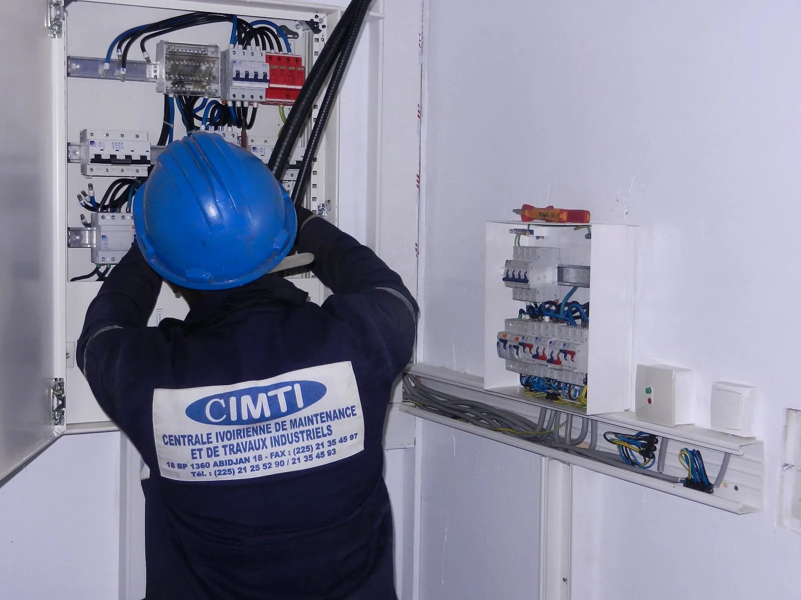 Électricien CIMTI casqué intervenant sur un tableau électrique